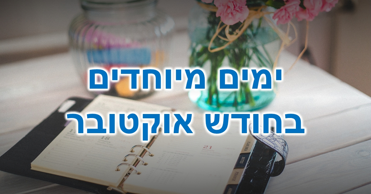 ימים מיוחדים בחודש אוקטובר: מחברת לוח שנה פתוחה על שולחן ליד אגרטל זכוכית עם פרחים ורודים וצנצנת זכוכית שקופה המכילה גירים צבעוניים.