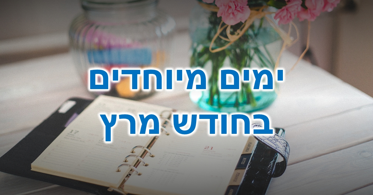 ימים מיוחדים בחודש מרץ: מחברת לוח שנה פתוחה על שולחן ליד אגרטל זכוכית עם פרחים ורודים וצנצנת זכוכית שקופה המכילה גירים צבעוניים.